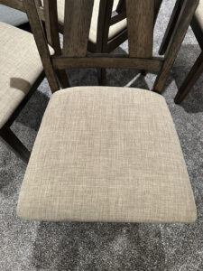 Dining chair with light upholstered seat after professional cleaning, illustrating the risks of DIY furniture cleaning when handling delicate fabrics.