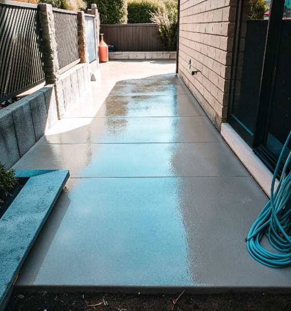 Freshly power washed concrete walkway beside a home, showing a clean bright surface in Toronto GTA.